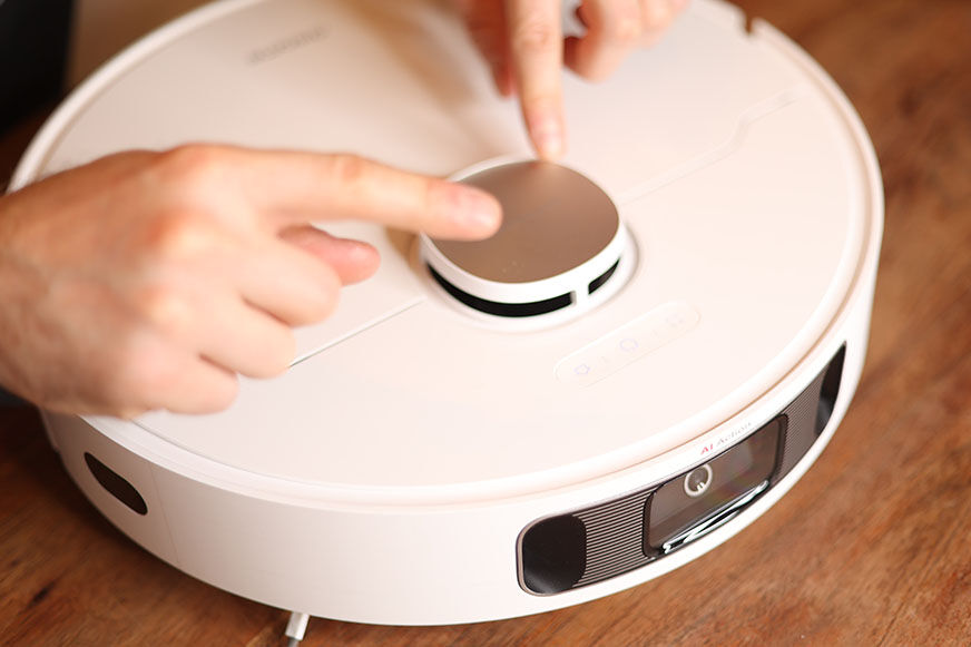 The laser navigation tower of the Dreame L10s Ultra is touched with both hands.